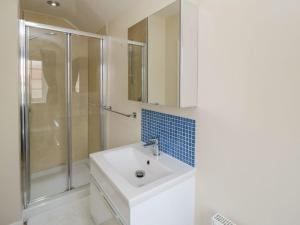 une salle de bain blanche avec lavabo et douche dans l'établissement Midsummer Cottage, à Wilton 9 autres photos