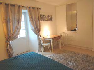 a bedroom with a bed and a table and a window at La Buissière - Gite Savane in Duravel