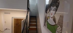 uma escada com um quadro de uma mulher na parede em Z40 - Budget Apartment em Budapeste