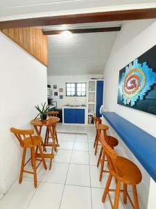 a living room with wooden chairs and a blue counter at Brothers Suites Centro Búzios in Búzios