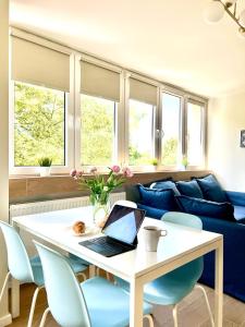 a living room with a table with a laptop on it at Legnica Apartament 36m2 Delux 3 in Legnica