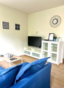 a living room with a blue couch and a tv at Legnica Apartament 36m2 Delux 3 in Legnica