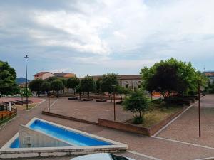 a swimming pool in a parking lot with a building at PIAZZA SANTANGELO - Home - in Busso