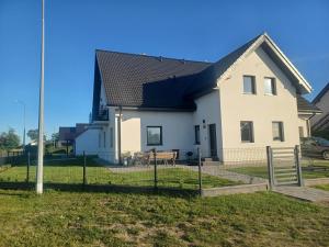 a white house with a black roof at Pokoje Gościnne Fuksja in Nowęcin