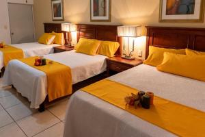 阿瓜斯卡连特斯Hotel San Antonio的酒店客房,设有三张带黄床单的床