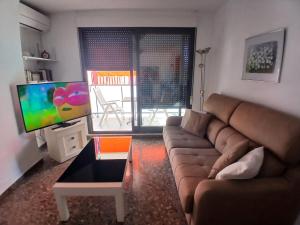 a living room with a couch and a television at Tikitita House in Gandía