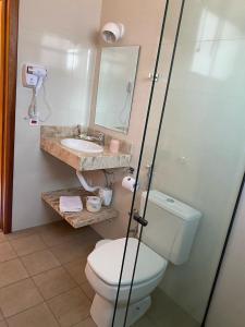 a bathroom with a toilet and a sink at Pousada Serra dos Sicalis in Serra Negra +20 photos