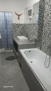 a bathroom with two sinks and a bath tub at Hotel LE BOEUF in Tuléar