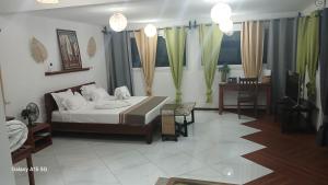 a bedroom with a bed and a table and chairs at Hotel LE BOEUF in Tuléar