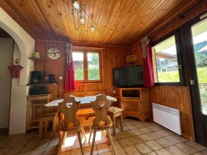 a dining room with a table and chairs and a tv at Appartement cosy pour 4 pers avec terrasse, proche commerces et télécabine à Morillon - FR-1-642-43 in Morillon
