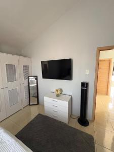 a bedroom with a tv on the wall and a dresser at Cheerful two bedroom home close to mall and Hellshire beach in Portmore