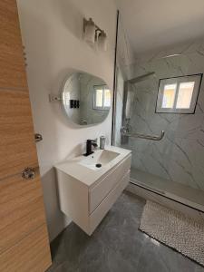 a bathroom with a white sink and a mirror at Cheerful two bedroom home close to mall and Hellshire beach in Portmore
