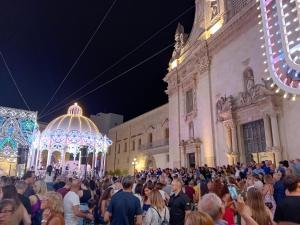 tłum ludzi stojących w nocy przed budynkiem w obiekcie Villa SALENTO2 -doppio terrazzo panoramico vista mare mozzafiato immersa nella natura w mieście Alessano