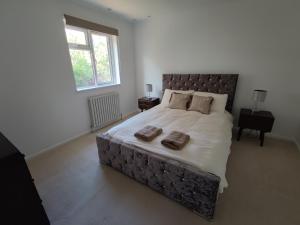 a bedroom with a large bed with two pillows on it at 3 bedroom HOUSE, Garden, PARKING, Wi-fi, CONTRACTOR STAY, close to the beach, shops, hospital, airport in Bournemouth +17 photos