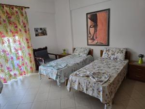 a room with two beds and a chair in it at Riviera in Polisi i Vogël