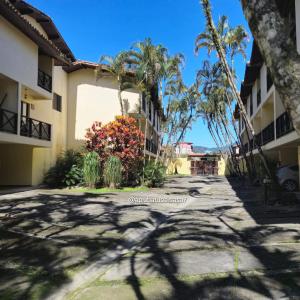 a street in front of a building with palm trees at Casa 7 em Ubatuba no Centro Condomínio com Piscina e Churrasqueira in Ubatuba