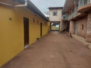an empty alley between two buildings with yellow walls at Hotel Avenida in Acailandia