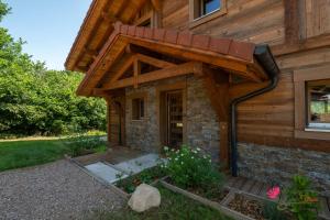 une maison en bois avec un toit à la mansarde dans l'établissement Le Domaine des Fleurs - Chalet Le Coeur de Marie, à Gérardmer
