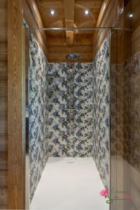 une douche avec une porte vitrée dans une pièce dans l'établissement Le Domaine des Fleurs - Chalet Le Coeur de Marie, à Gérardmer