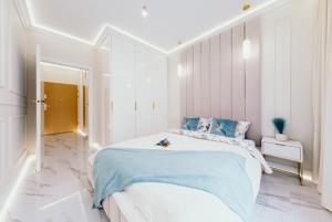 a bedroom with a large bed with a blue blanket at Sea Shell Stadium Brzeźno Beach in Gdańsk
