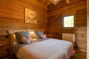 - une chambre avec un lit avec deux cœurs dans l'établissement Le Domaine des Fleurs - Chalet Le Coeur de Marie, à Gérardmer