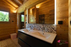 une salle de bain avec un lavabo et un miroir dans l'établissement Le Domaine des Fleurs - Chalet Le Coeur de Marie, à Gérardmer 24 autres photos