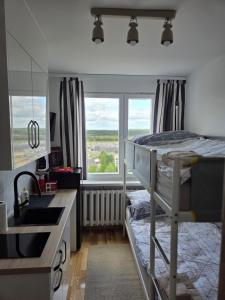 a bedroom with a bunk bed and a kitchen with a sink at STUDIO dla 2 osób in Suwałki