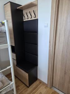 a black closet with a ladder in a room at STUDIO dla 2 osób in Suwałki +8 photos