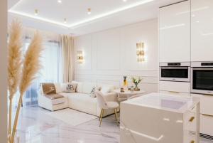 a white living room with a couch and a table at Sea Shell Stadium Brzeźno Beach in Gdańsk