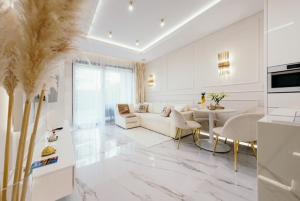 a white living room with a couch and a table at Sea Shell Stadium Brzeźno Beach in Gdańsk