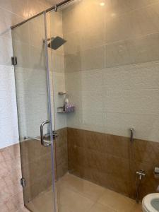 une douche avec une porte vitrée dans une salle de bain dans l'établissement Cottage in Changla Gali - Secluded, Cozy Apartment, à Chhāngla Gali 18 autres photos