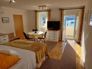 a bedroom with a bed and a table and a television at Apartment Nona in Korčula