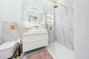 a bathroom with a sink and a toilet and a mirror at Sea Shell Stadium Brzeźno Beach in Gdańsk +59 photos