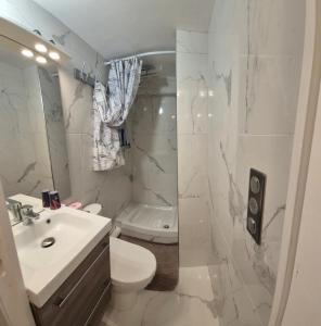 a white bathroom with a sink and a toilet at Chambres meublées Sdb Wc et accès privatifs - Suite familiale in Champigny-sur-Marne