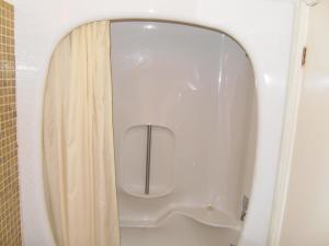 a white toilet in a bathroom with a curtain at Virden Motel in Virden +18 photos