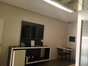 a living room with a flat screen tv on the wall at STILLUS - Hotel e Motel in Imperatriz