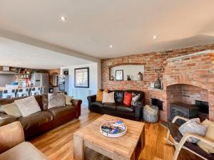 - un salon avec un canapé et une cheminée en briques dans l'établissement Mews Cottage, à Trowbridge