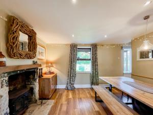 - un salon avec une cheminée et une table en bois dans l'établissement Mews Cottage, à Trowbridge