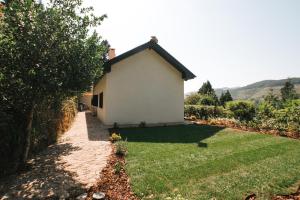 un pequeño edificio blanco con un patio de césped en Casa Colina e Lobos by Quantique, en Vieira do Minho