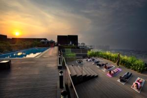 a rooftop of a building with a pool and people sitting at The Waverly Hotel & Residences in Bangalore