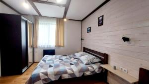 a bedroom with a bed and a wooden wall at Під Боржавою in Pilipets