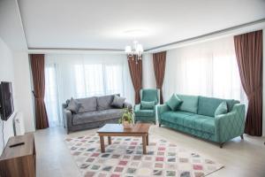 a living room with two green couches and a coffee table at Oxseya Rezidans in Yomra