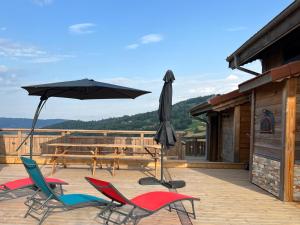 a patio with a table and chairs and an umbrella at BEL'M Amiral in Fresse-sur-Moselle