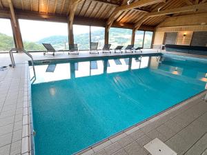 a large swimming pool with chairs in a building at BEL'M Amiral in Fresse-sur-Moselle +40 photos