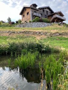 an old house on a hill next to a body of water at BEL'M Amiral in Fresse-sur-Moselle