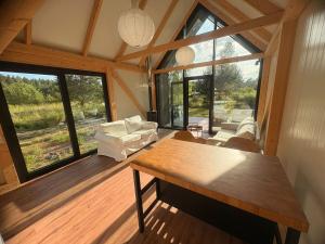 a living room with a table and a large window at Dole Nature loft in Pļavniekkalns