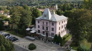 una vista aerea di un edificio bianco con una torre di Hotel Grand a Řevnice