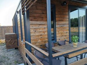 a wooden cabin with a table and chairs on a deck at Corner Bungalow in Ulcinj +5 photos