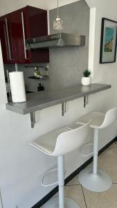 a kitchen with two white chairs and a counter at Studio lumineux avec balcon à Nice in Nice
