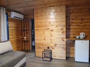 a room with a wooden wall with a refrigerator and a counter at Corner Bungalow in Ulcinj